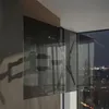 A TV wall mount is attached to a wall, with a city skyline visible through a window in the background. Produktbild-Vorschau