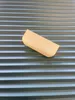 A beige-colored product is placed on a gray, horizontally striped surface. Produktbild-Vorschau