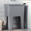 A grey resin laundry tub with a faucet and plumbing visible underneath, placed in a tiled room next to a washing machine. Náhľad obrázku produktu
