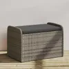 A grey poly rattan storage bench with a dark grey cushion is placed on a wooden deck against a light grey wall. Anteprima dell’immagine prodotto