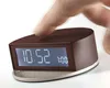 A finger pressing down on the top of a digital alarm clock. Produktbild-Vorschau