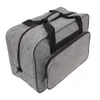A grey sewing machine storage bag with black handles and zippers, shown from a slightly elevated side angle on a white background. Náhľad obrázku produktu