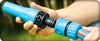 Hands connecting a blue hose connector in an outdoor setting. Voir les images du produit