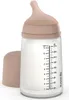 A baby bottle with a beige cap and a beige nipple, filled with a white liquid. The bottle has measurement markings on the side. Produktbild-Vorschau