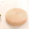 A round, woven floor cushion is placed on a light-colored wooden floor. Produktbild-Vorschau