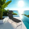 A black lounge chair with a sunshade is set up on a patio next to an infinity pool overlooking the ocean on a sunny day. Náhled obrázku produktu