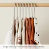 Children's clothes hanging on hangers on a wooden rod. Anteprima dell’immagine prodotto