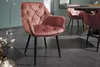 A dusty rose velvet armchair with tufted detailing and black metal legs sits on a dark wood-look floor. Produktbild-Vorschau