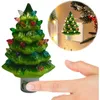 A hand is shown pressing a button on a ceramic Christmas tree night light. A smaller inset image shows the night light plugged into a wall socket. Náhľad obrázku produktu