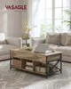 A living room scene featuring a coffee table with a laptop and decor, in front of a sofa and window. Náhled obrázku produktu
