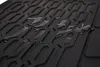 A close-up of a black rubber car mat with water droplets on its textured surface. Produktbild-Vorschau