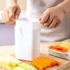 Hands holding a white vegetable slicer over a cutting board with sliced vegetables. Produktbild-Vorschau