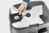A hand is shown inserting a vacuum cleaner bag into a vacuum cleaner. Produktbild-Vorschau