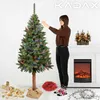 A woman decorates a Christmas tree in a room with a fireplace. Anteprima dell’immagine prodotto