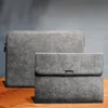 Two grey laptop sleeves are displayed on a wooden surface against a grey background. Produktbild-Vorschau
