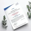 A certificate document is presented on a white surface with decorative green leaves on the sides. Produktbild-Vorschau