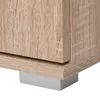 A close-up view of the bottom corner of a wooden cabinet, showing its texture and a small grey support. Produktbild-Vorschau