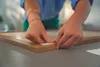 A person's hands are shown applying a tesa Powerstrip to the corner of a wooden picture frame. Anteprima dell’immagine prodotto