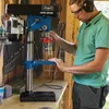 A man is using a drill press in a workshop. Produktbild-Vorschau