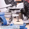 A close-up view of a miter saw with a piece of wood being cut. Voir les images du produit