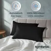 Two black pillowcases are laid out on a white bed with a grey tufted headboard in the background. There are informational icons and text above the pillows. Produktbild-Vorschau