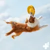 A dog jumping in the air to catch a frisbee against a blue sky with clouds. Náhľad obrázku produktu