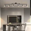 A modern kitchen with a dining table and chairs, illuminated by a track light fixture. Podgląd zdjęcia produktu