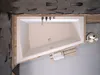 A top-down view of a modern bathtub with a wooden surround and a textured wall in the background. Produktbild-Vorschau