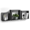 Three grey cube shelves mounted on a white wall, each containing decorative items. Produktbild-Vorschau