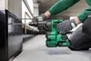 A person is using a cordless hammer drill to drill into a wall. Produktbild-Vorschau