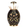 A decorative black and gold toothpick holder with toothpicks sticking out. Náhled obrázku produktu
