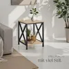 A modern living room setting with a side table next to a sofa, featuring decorative items and plants. Náhled obrázku produktu
