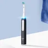 A black and white electric toothbrush with a blue light glow, set against a light blue background and a white surface. Voir les images du produit