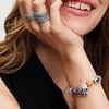 A woman's hand with jewelry, showing a bracelet with charms. Produktbild-Vorschau