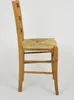 Side view of a wooden chair with a woven seat. Produktbild-Vorschau