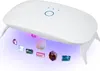 A white UV resin curing lamp with its legs extended, illuminating several colorful gemstones and a seashell with purple light. Produktbild-Vorschau
