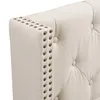 Close-up view of a tufted headboard with nailhead trim. Náhled obrázku produktu