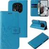 A collage of images showing a blue floral and butterfly embossed flip phone case from multiple angles, including the inside with card slots and a phone inserted. Produktbild-Vorschau