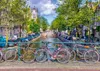 A picturesque canal scene in Amsterdam with bicycles parked along the railing. Produktbild-Vorschau