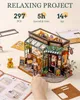 A miniature DIY model of a bistro is shown, with text indicating it's a relaxing project with 297 pieces and an assembly time of 5 hours for ages 14+. Produktbild-Vorschau