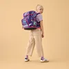 A young girl is wearing a backpack and looking over her shoulder. Produktbild-Vorschau