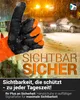 A gloved hand giving a thumbs up in a snowy environment with a car in the background. Produktbild-Vorschau