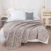 A neatly made bed with a beige blanket with a leaf pattern, white pillows, and a decorative pillow. Podgląd zdjęcia produktu