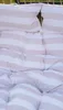 A close-up view of a striped hammock or swing chair with pillows. Podgląd zdjęcia produktu
