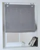 A gray Roman blind is shown hanging in a window. Produktbild-Vorschau