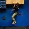 Ein Kletterer nutzt das Trainingboard "VerticalBoard FIRST" von YY Vertical; während er an einer blauen Wand schwebt. Náhľad obrázku produktu