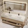 A modern bathroom vanity with a double sink, wooden drawers, and a large LED mirror. Produktbild-Vorschau