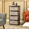 A storage unit with fabric drawers is placed in a living room setting next to a sofa and armchair. Podgląd zdjęcia produktu