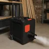 A black diesel heater with orange accents is shown in a workshop or garage setting, emitting a stream of white vapor from its nozzle. Voir les images du produit