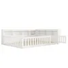 A white daybed with a slatted mattress base, a built-in bookshelf along the back and sides, and a slatted gate on one side. Anteprima dell’immagine prodotto